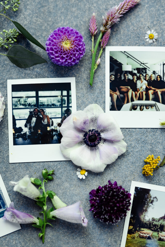 A white flower centered with Polaroid prints placed around it.